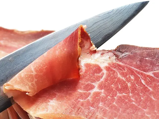 knife cutting ham