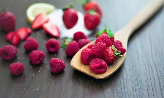 raspberries and strawberries on a spoon
