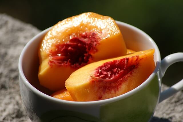 sliced peach in a mug